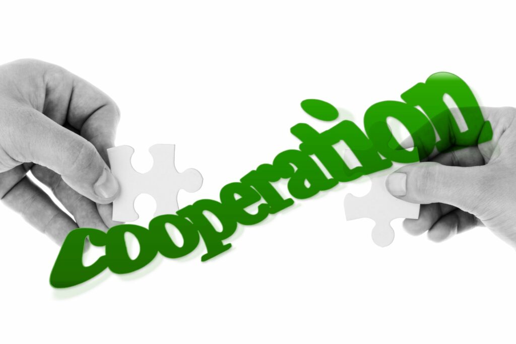 Fotomontage: Hände mit Puzzleteilen legen "Cooperation" (Copyright: pixabay.com)